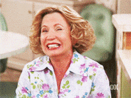 TV gif. Debra Jo Rupp as Kitty from That '70s Show laughing so hard that she doubles over.