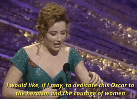 Celebrity gif. Emma Thompson's acceptance speech at the 1993 Oscars. She's wearing a glittery teal dress and holding an Oscar in her hand as she speaks with sincerity into a microphone on stage. Text, "I would like, if I may, to dedicate this Oscar to the heroism and the courage of women."