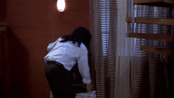 Movie gif. Tommy Wiseau as Johnny in The Room. He's throwing a tantrum in a room and he lifts up a television set and runs with it to an open window. He proceeds to toss the television out of the window.