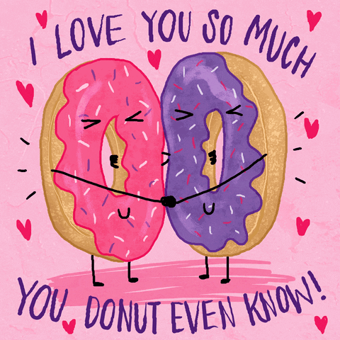 Digital art gif. Pink and purple donuts hold each other close with stick arms. Their eyes closed and simple smiles on their donut faces as red hearts dance around them. Text, 
