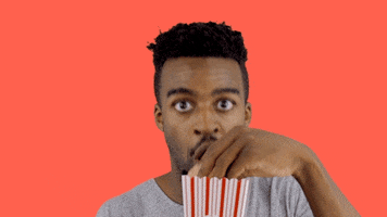 Celebrity gif. Landon Moss stares raptly at us as he gobbles a handful of popcorn, and his eyebrows go up and down.