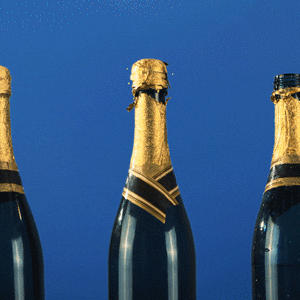 Gif přání k svátku s posunujícími se lahvemi šampaňského, jejichž špunty samovolně vystřelují.