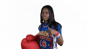 Video gif. Woman in a Harlem Globetrotters jersey waves her hand dismissively, like she wants us to go. She then punches us with an oversized boxing glove. Text, “pow!”