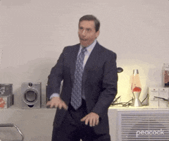 The Office gif. Steve Carell as Michael Scott stands in front of a home stereo and dances awkwardly.