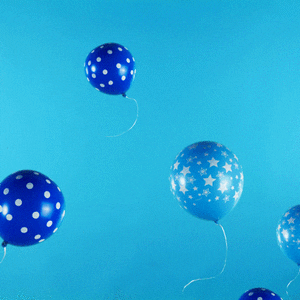 Digital art gif. Light and dark blue balloons with stars and dots on them floating up, while one balloon pauses in the middle with the word "yay!" on it.