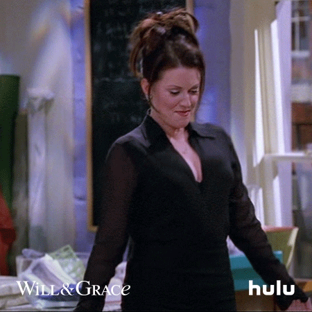 TV gif. Megan Mullally as Karen in Will and Grace sticks her tongue out, shakes her chest, and shimmies her shoulders.