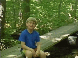 Video gif. A young boy is sitting on a log in the forest and he looks grateful as he gently says, "I just wanted to say thanks, partner."
