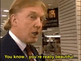 Political gif. Donald Trump staring intently at Rudy Giuliani dressed in a pink dress and wig. He leans in to say, "You know... you're really beautiful..." Rudy smiles and looks away.