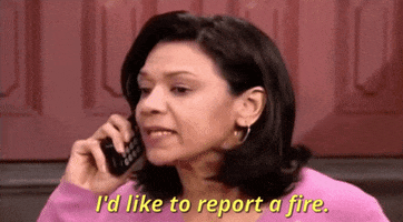 Celebrity gif. Sonia Manzano speaks into a telephone with urgency, "I'd like to report a fire."
