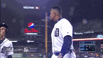 Sports gif. Miguel Cabrera and a batboy do a low high five, then raise their arms and link elbows before walking past each other.