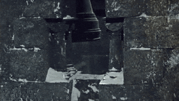 Movie gif. From Dracula Has Risen from the Grave, snow falls on a stony wall.
