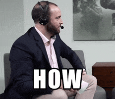 Video gif. A bearded man wearing a blazer and headset has just seen something shocking. He glances at us as he gives an exasperated shout offscreen. Text, "How."