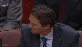 Video gif. Man in a suit slowly turns his head to reveal his face that’s tight with rage. He has a scary look in his eyes.
