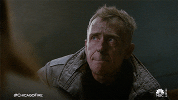 TV gif. David Eigenberg as Christopher in Chicago Fire bites his lip and nods his head in agreement as he holds back tears. 