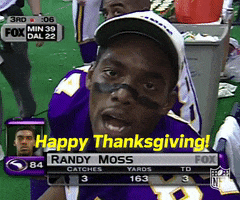 Sports gif. Randy Moss sits on the bench with a ball cap on, his player profile displayed on screen, as he says to us, "Happy thanksgiving!"