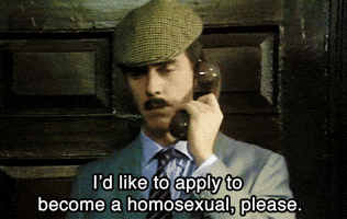TV gif. From A Bit of Fry and Laurie, Hugh Laurie, dressed in a suit and newsboy cap with a tiny mustache, speaks into a telephone, saying, "I'd like to apply to become a homosexual, please," which appears as text.