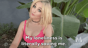 SNL gif. Chloe Feinman impersonates Brittney Spears in a blonde wig and hot pink sports bra during a Covid-era selfie sketch. She bobs her head side to side then brings her hands to Namaste. Caption reads, "My loneliness is literally saving me."