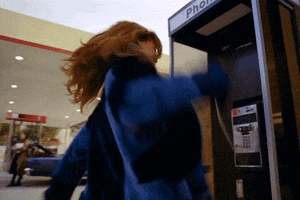 Music video gif. Rihanna swings her arm as she repeatedly slams a receiver into a payphone booth.