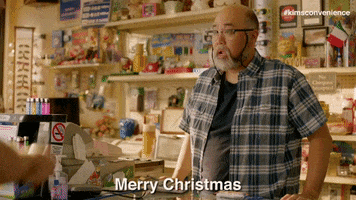 TV gif. Paul Sun-Hyung Lee as Mr. Kim on Kim’s Convenience stands behind his counter and says sarcastically, “Merry Christmas.”