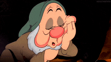 Disney gif. Sleepy, one of the Seven Dwarves from Snow White, has his hand in his palm and he struggles to stay awake. His eyes are very heavy lidded and he finally sinks into sleep.