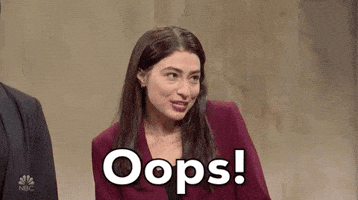 SNL gif. Actor Melissa Villasenor impersonating Alexandria Ocasio Cortez shrugs and puts her hands to her mouth with a mischievous smile. The text says, "Oops," but she doesn't seem to be very sorry at all. 