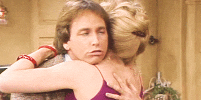 TV gif. Jack Ritter as Jack in Three's Company. He's hugging a woman and rubbing her back intensely as his eyes roll back in perverted pleasure.