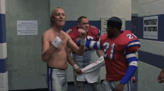 Movie gif. Rhys Ifans as Nigel in The Replacements is shirtless, and makes a silly face and pounds his right hand into his left palm, nodding to one of the other football players in the locker room. The other player walks away unamused. 