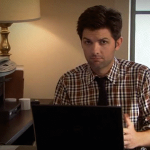 Parks and Recreation gif. Adam Scott as Ben sits at a desk with a laptop. In a series of cuts of the same shot repeated, there's a closeup of his face as he looks at us confused, then he shakes his head, putting his hands out as if to say, "what?"