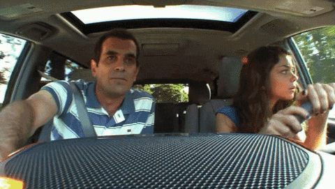 Characters from Modern Family freaking out while driving a car.