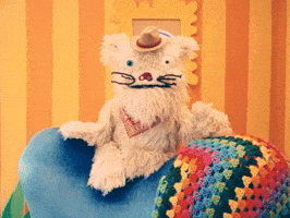 TV gif. Scruffy, a fluffy puppet dog wearing a cowboy hat, in "Happy Place" sits on the back of a blue chair, flapping his mouth open and closed in a bright living space decorated with cartoonish decor. Text, "A good night."