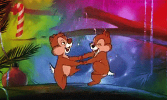 Disney gif. Chip and Dale in Mickey's Magical Christmas. They're holding hands and are dancing in circles on a branch of the Christmas tree.