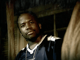 Celebrity gif. Big Boi shakes his head disapprovingly as he stands by a window between billowing curtains in the rain.