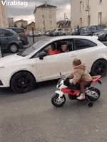 Kid On Toy Motorbike Challenges Driver To A Race GIF by ViralHog