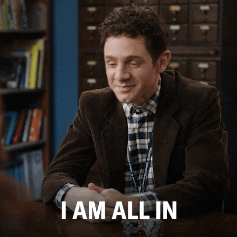 TV gif. Jacob Hill as Jacob in "Abbott Elementary" sits at a table and swoops his hands out in an energetic gesture saying, "I am all in!'