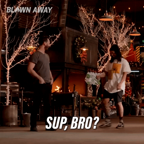 Reality TV gif. Two contestants on a Christmas episode of Blown Away give each other a fist bump in front of a decorated set. Text, “Sup, bro?”