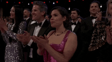 Oscars 2024 GIF. America Ferrera, at the Oscars, smiles to herself as she applauds.
