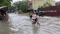 Cyclists Ride Through Flooded Manila Streets
