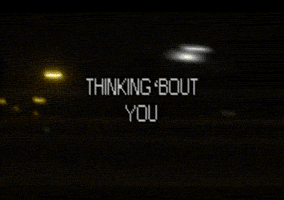 Video gif. Lo-fi video footage of what looks like a nighttime streetscape. Text, "Thinking 'bout you."