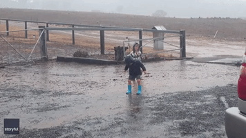 Boys Skip Chores to Splash in Puddles as Rain Hits Drought-Stricken Australian Farm