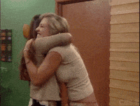 Reality TV gif. Two women from Big Brother are ecstatic as they hug closely and jump around. Their eyes are closed and their faces are filled with happiness.