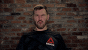 Celebrity gif. MMA fighter Stipe Miocic spreads his arms out wide, mimicking an explosion. He makes sound effects with his mouth.