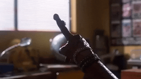 Movie gif. ET from ET wears multiple bracelets on his alien arm as he points a finger towards a window. 