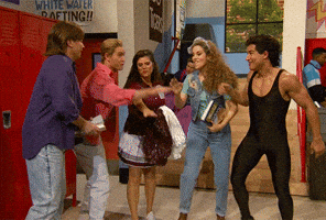 Tonight Show gif. Jimmy Fallon, Mark Paul Gosselaar, Tiffani Amber Thiessen, Elizabeth Berkley and Mario Lopez dressed as characters of Saved by the Bell all put a hand together in the middle and do a team cheer.