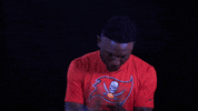 Sports gif. Tampa Buccaneers football player Chris Godwin claps as if satisfied.