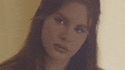 Celebrity gif. A disappointed Lana Del Rey looks sadly at the ground.
