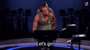 Video gif. Riding on his Peloton, instructor Alex Toussaint waves his arm in encouragement as he says enthusiastically, “Let’s go! Come on! Ha!”