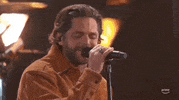 Academy of Country Music Awards gif. Man in brown button up sings intensely with forehead vains showing and eyes closed and swaying head from side-to-side.