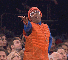 Celebrity gif. An annoyed Spike Lee stands up at a sporting event, throwing a hand in the air and saying, “Come on.”