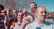 Video gif. A group of people all look at us and cringe. They shake their heads and give big thumbs down as they frown in disgust. 