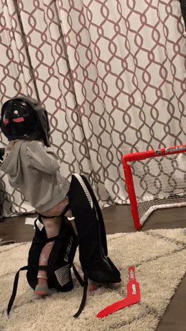 Little Girl Tries on Brother's Hockey Gear